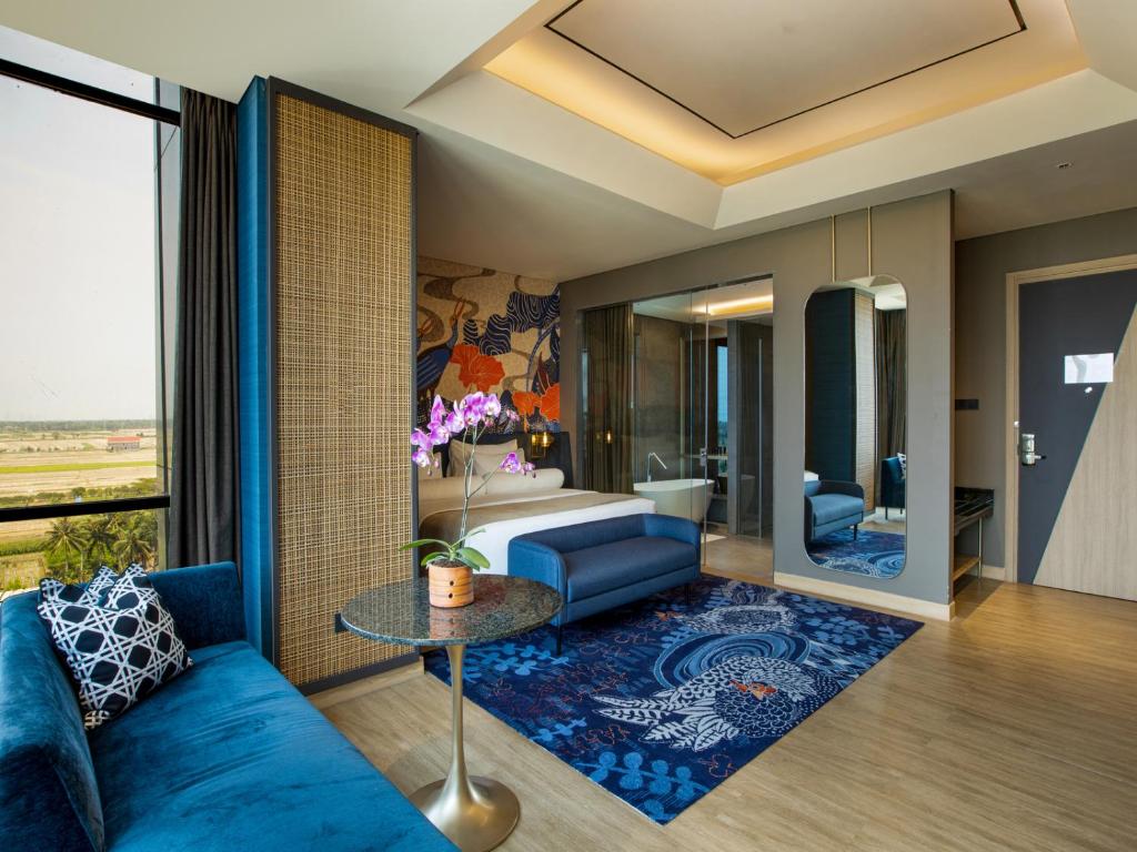 a living room with a blue couch and a table at MORAZEN Yogyakarta in Temon