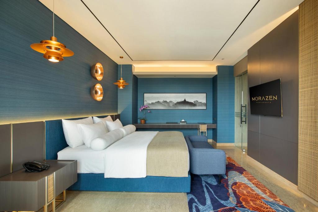 a hotel room with a bed and a desk at MORAZEN Yogyakarta in Temon