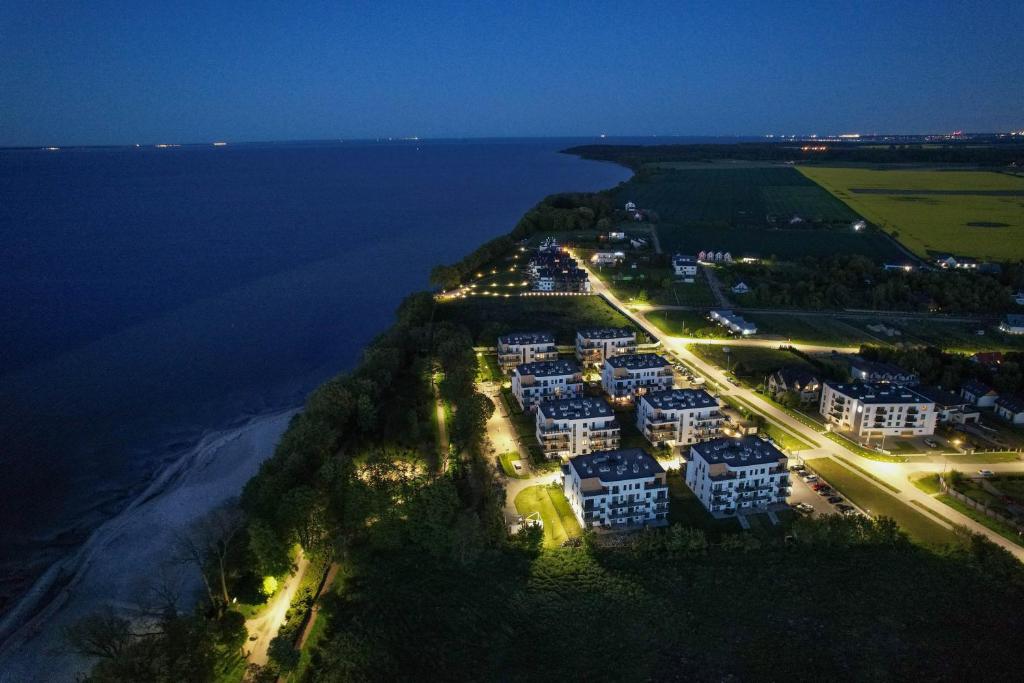 una vista aérea de un complejo cerca del océano por la noche en Puck Nexo apartament u Doroty 2os en Puck