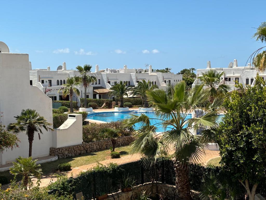 uma vista para um resort com uma piscina e palmeiras em PEQUEÑO PARAISO em Cala d´Or