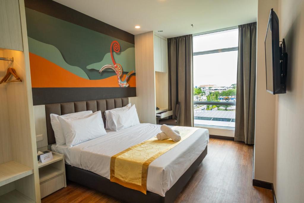 City Rise Hotel Miri في ميري: غرفة فندقية بسرير ونافذة كبيرة