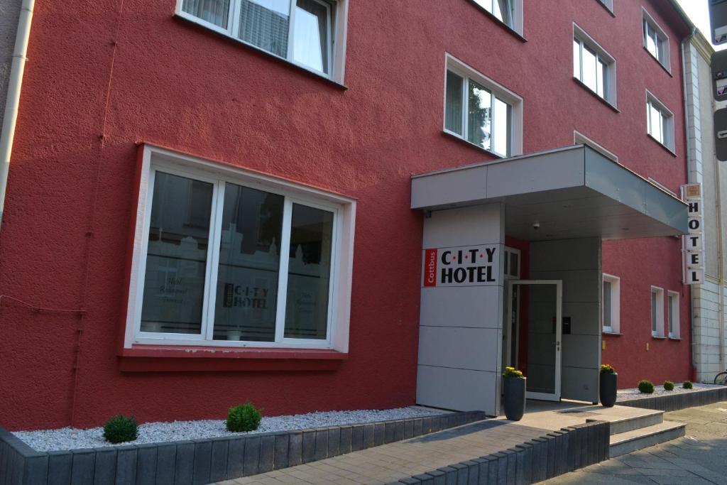 um edifício vermelho com uma placa que lê o hotel da cidade em City-Hotel Cottbus em Cottbus