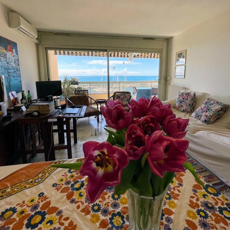 un vase de fleurs sur une table dans le salon dans l'établissement Alloggio fronte mare vista bellissima Mentone Garavan, à Menton