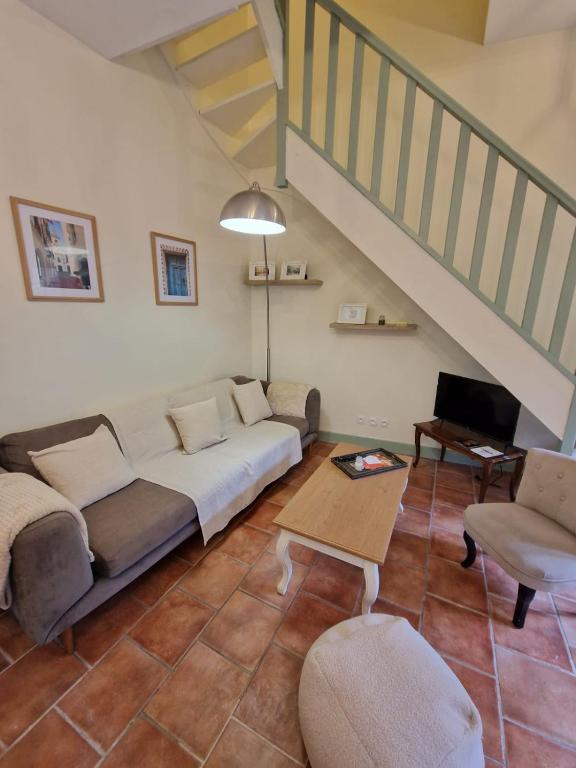 un salon avec un canapé et un escalier dans l'établissement Le Logis Saint Roch, à Pézenas