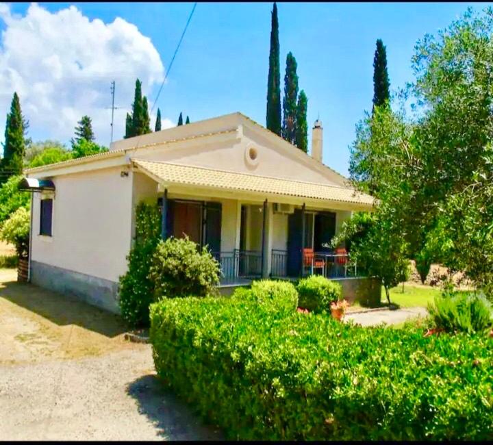 una piccola casa bianca con cespugli di fronte di Eirini's House Corfu a Kynopiástai