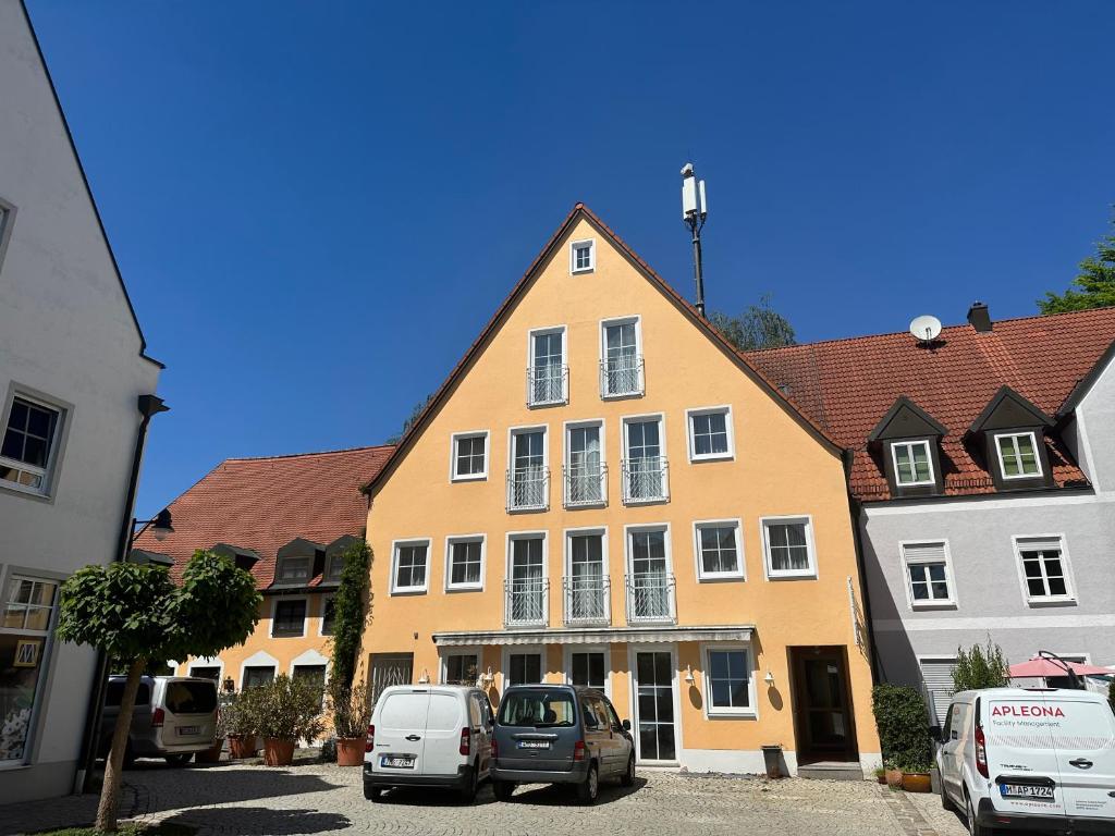 a yellow building with cars parked in front of it at ST Hotel in Reichertshofen