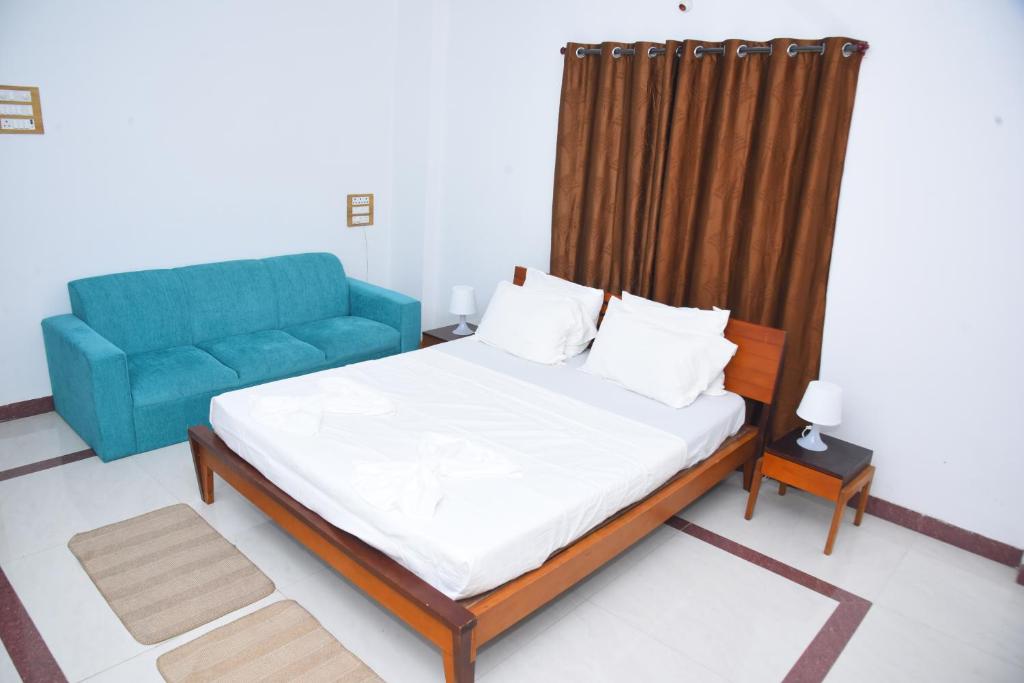 1 dormitorio con 1 cama y 1 sofá azul en Solis Stay, en Solapur