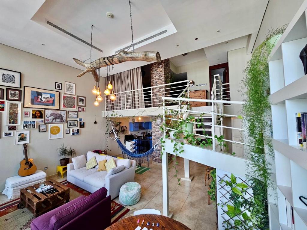 杜拜的住宿－City Haven 1br Loft Remote Work, Projector Tv，客厅设有白色沙发和楼梯。
