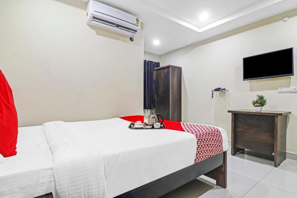 um quarto com duas camas e uma televisão em Super OYO Honey Heights Near Botanical Garden em Hyderabad