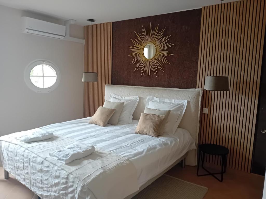 a bedroom with a large bed with white sheets and pillows at La porte rêvée... in Saint-Nicolas-de-la-Grave