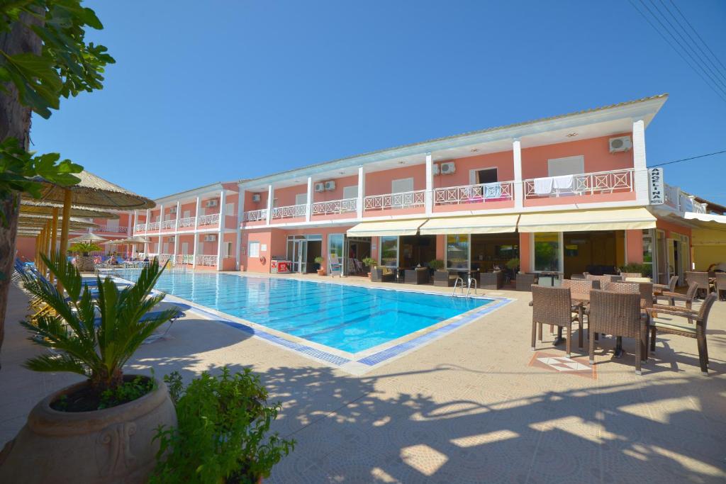 un hotel con piscina frente a un edificio en Angelina Hotel & Apartments, en Sidari