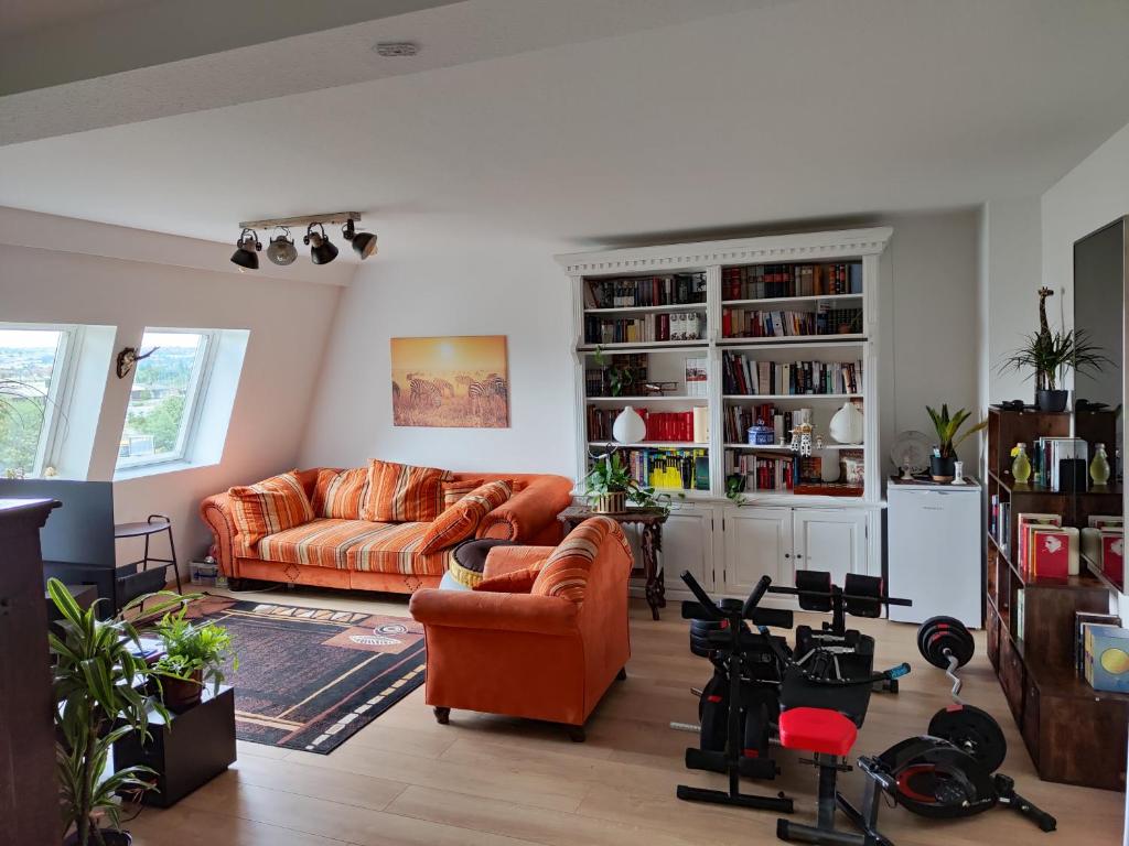 salon z pomarańczową kanapą i półką na książki w obiekcie Dresden Friedrichstadt w Dreźnie