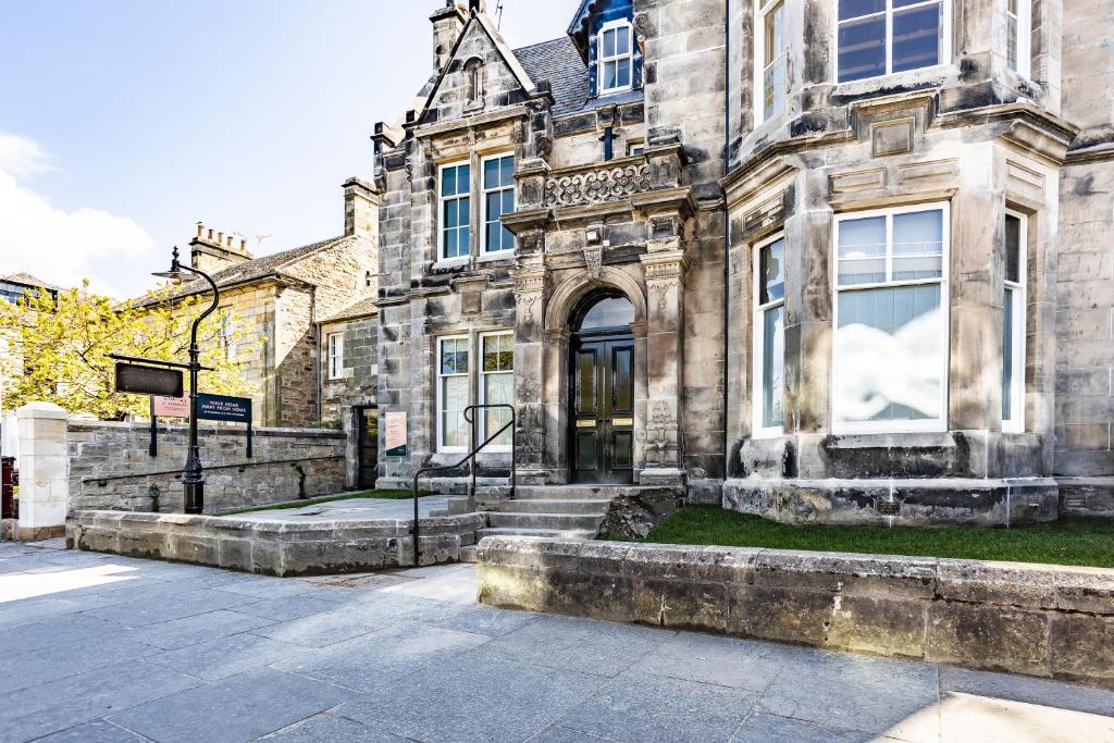 un vecchio edificio in pietra con scale di fronte di No1 Apartments & Bedrooms St Andrews - St Mary's a St Andrews