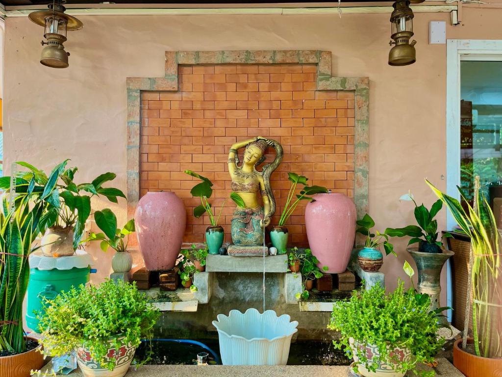 fontanna z roślinami przed ścianą z cegły w obiekcie Baan Baramee House w mieście Chiang Rai