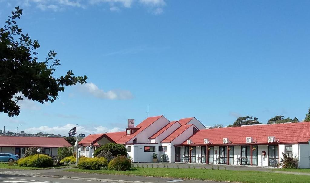 una fila de casas con techos rojos en una calle en Gateway Motor Lodge - Wanganui, en Whanganui