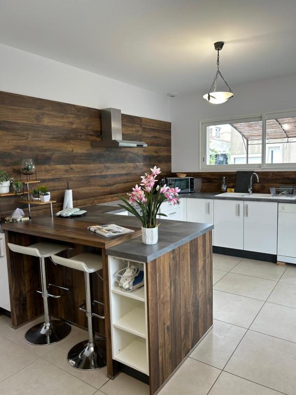 une cuisine avec un comptoir avec des fleurs dessus dans l'établissement Villa Mirabelle 4 personnes, à Châteauneuf-de-Gadagne