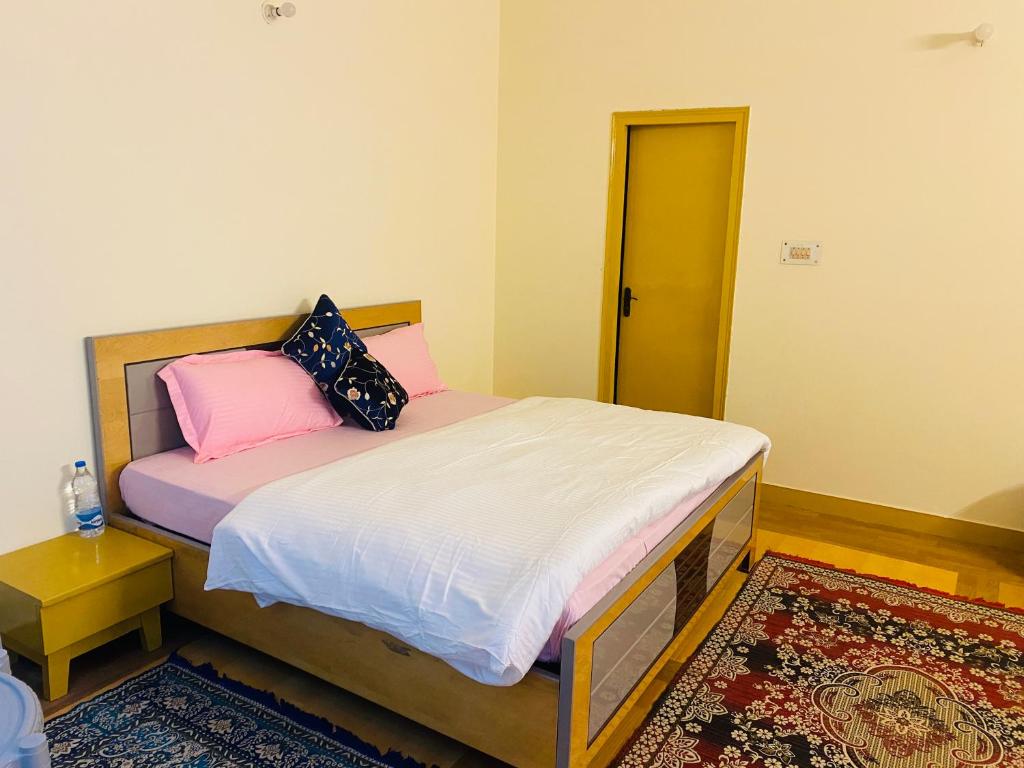 um quarto com uma cama com lençóis cor-de-rosa e brancos em Kumaon Hills view Homestay em Mukteshwar