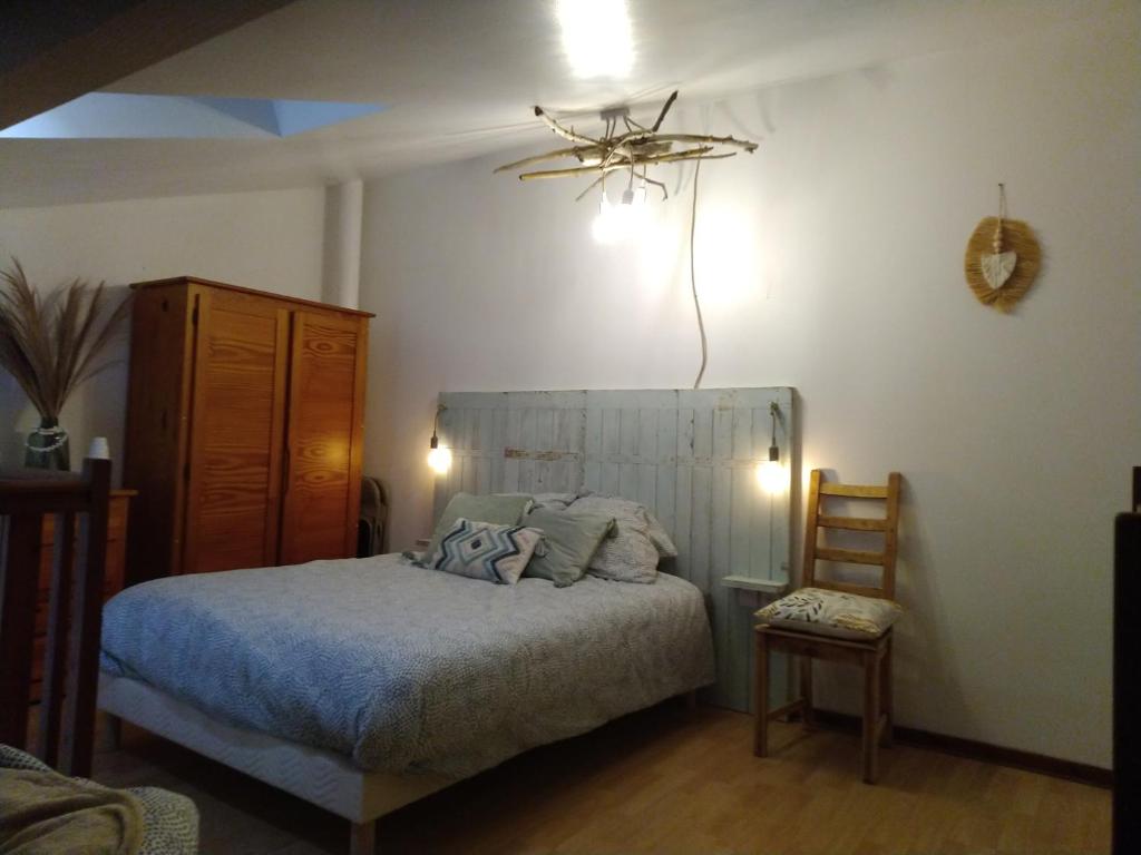une chambre avec un lit et un ventilateur de plafond dans l'établissement le studio de Monta, à Vendays-Montalivet