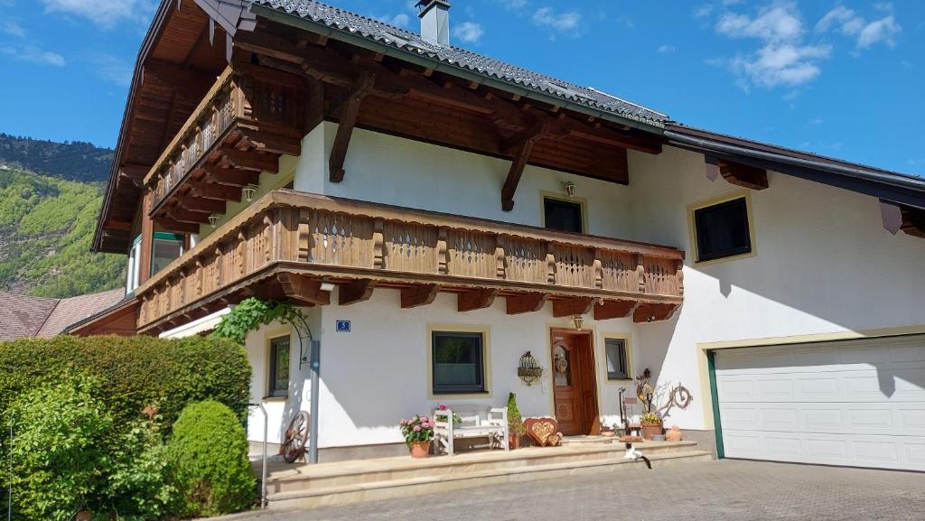 een groot wit huis met een houten balkon bij Ferienwohnung Seeberg mit Almfeeling in Faistenau