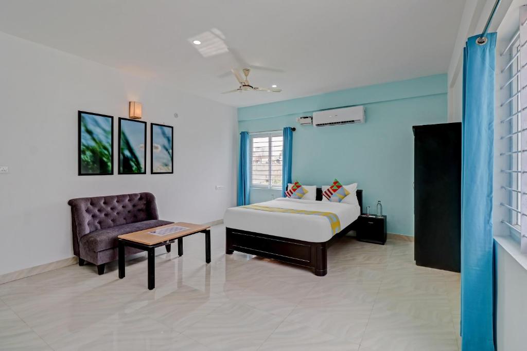 1 dormitorio con 1 cama, 1 sofá y 1 silla en OYO Nr Royal en Bangalore