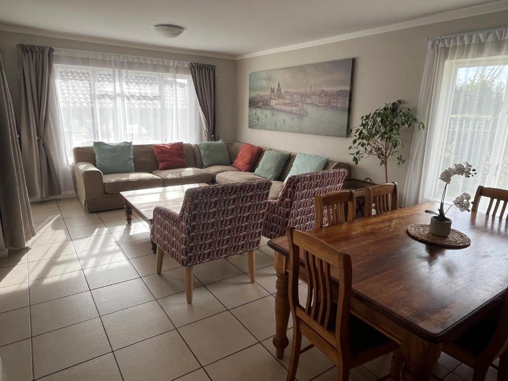 a living room with a couch and a table at Beautiful 3 Bedroom Ground floor apartment - 66 Santini Village in Plettenberg Bay