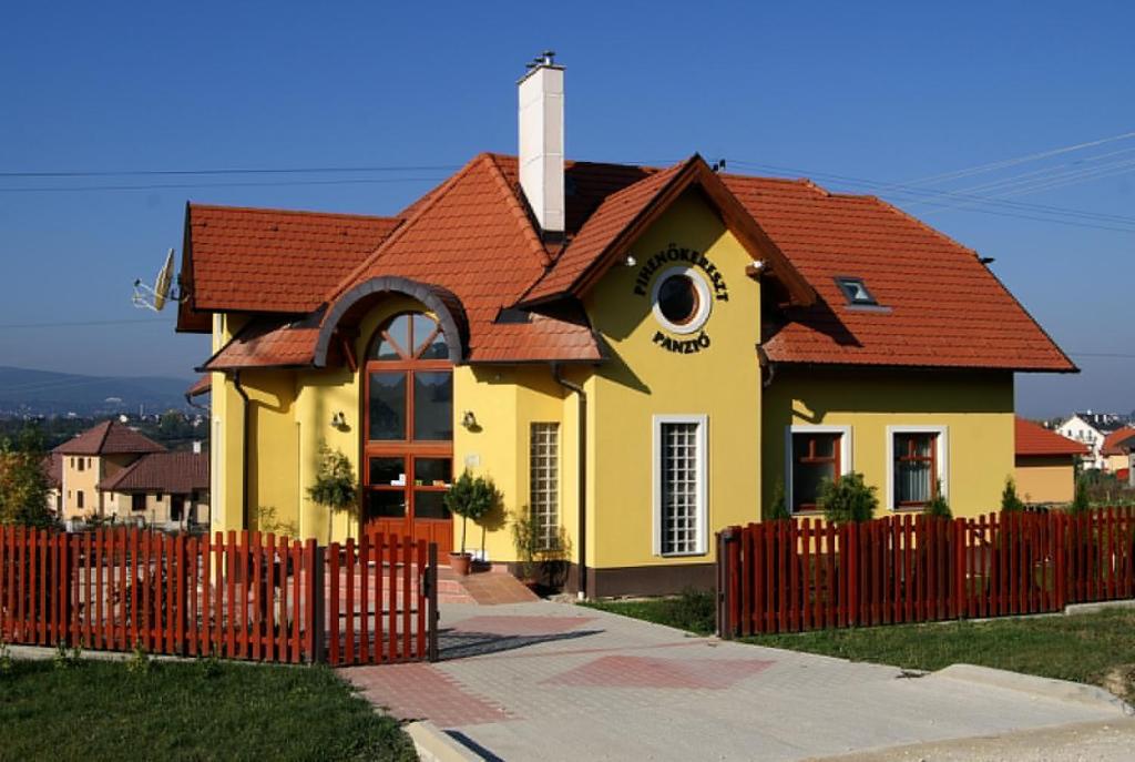 a small yellow house with a red roof at Pihenőkereszt Panzió in Sopron