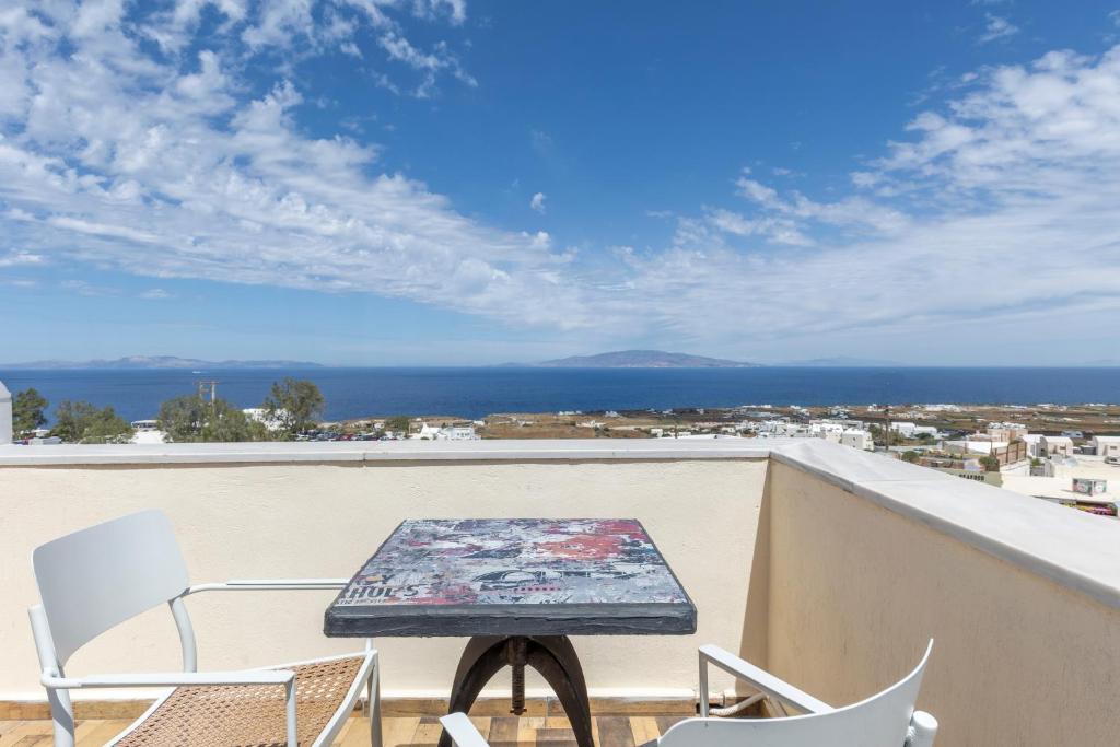 una mesa en un balcón con vistas al océano en UtopOia Apartment, en Oia
