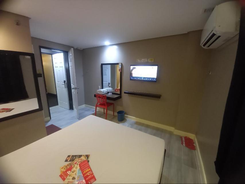 una camera con tavolo e televisore a parete di Hotel Sogo Fairview a Quezon City