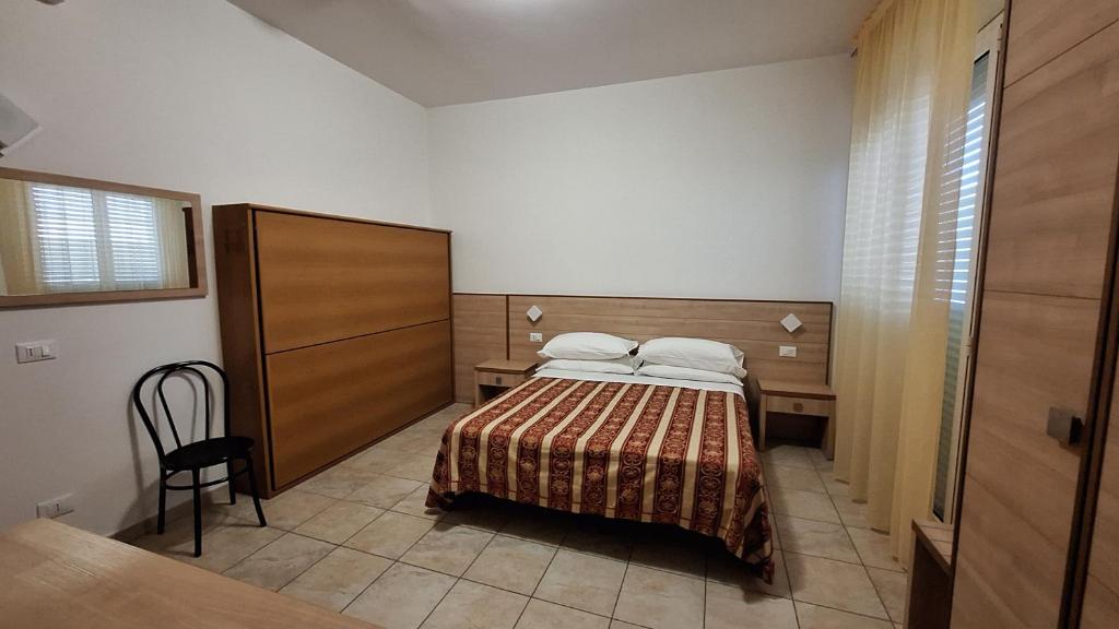 チェルヴィアにあるHotel Massimoのベッドルーム1室(ベッド1台、テーブル、椅子付)