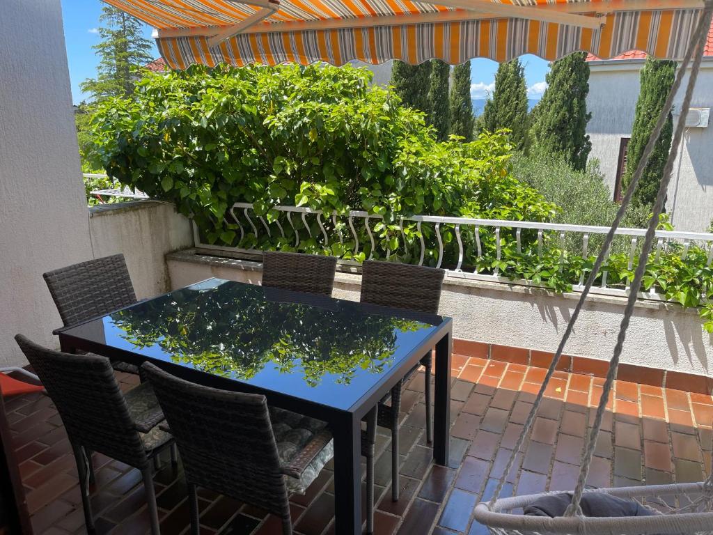 una mesa y sillas en un balcón con plantas en Apartments Natasa, en Punat