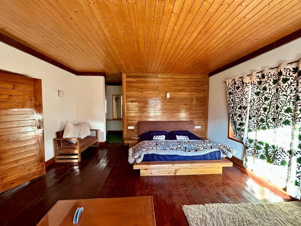 - une chambre avec un lit et un plafond en bois dans l'établissement The Trout Streamm, à Gulmarg
