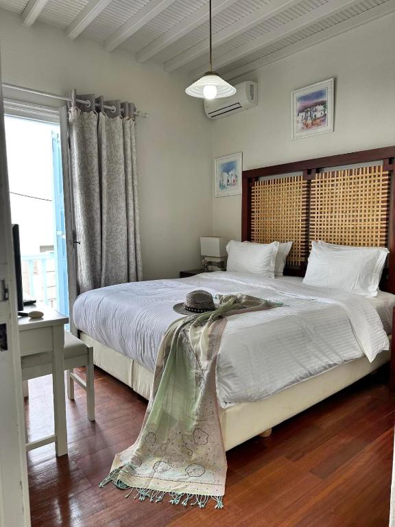 a bedroom with a large bed with a wooden headboard at Le Coq Apartments in Mikonos