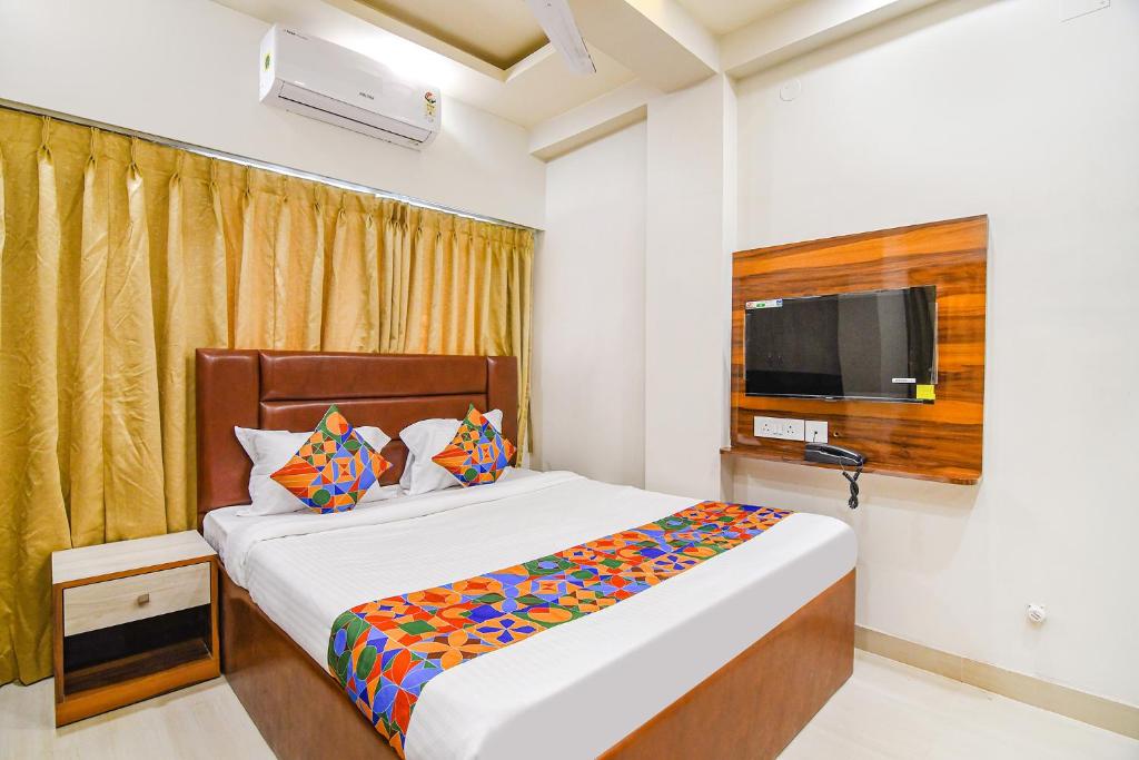 een slaapkamer met een bed en een televisie. bij FabHotel The Luxurie International in kolkata