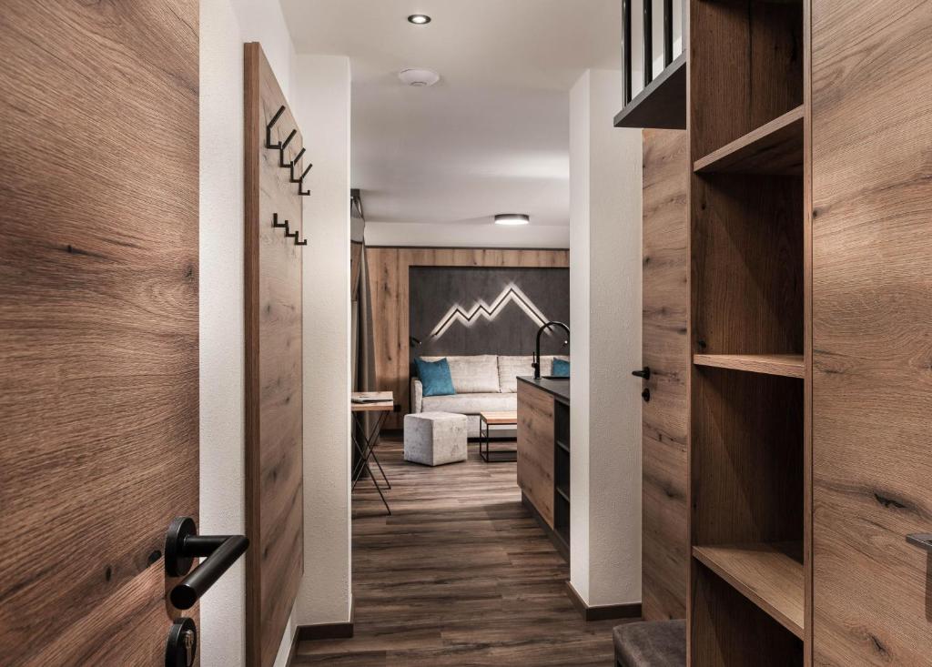 a hallway with wooden walls and a bedroom with a bed at Apartments Niederseer in Saalbach Hinterglemm