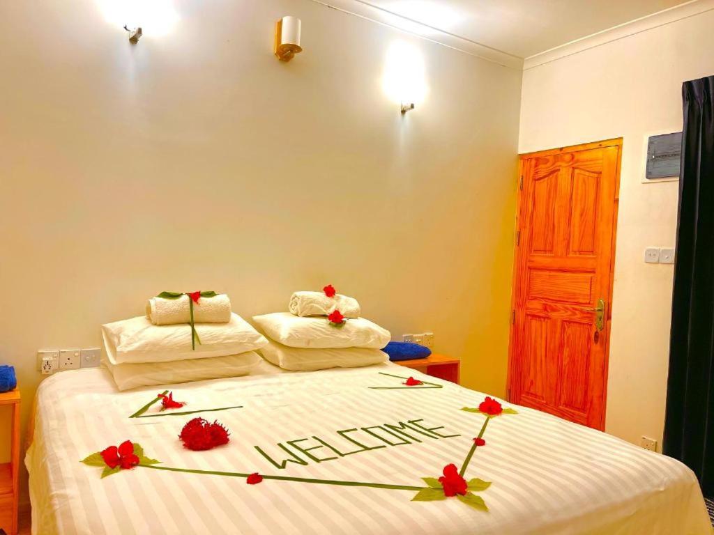 Un dormitorio con una cama con flores. en Sunny Side Inn Thoddoo, en Thoddoo
