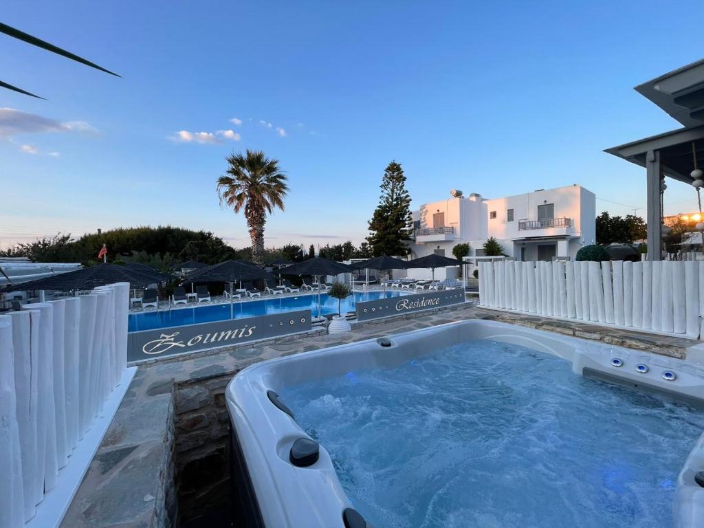 a hot tub on the patio of a resort at Zoumis Residence in Naousa