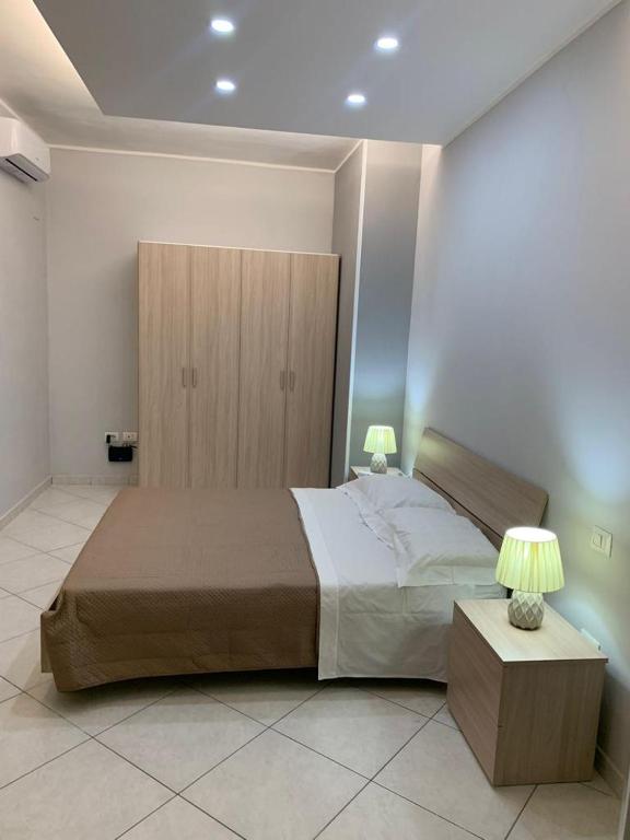 a bedroom with a large bed and two lamps at Bilocale Ottaviano City Sunflower in Ottaviano