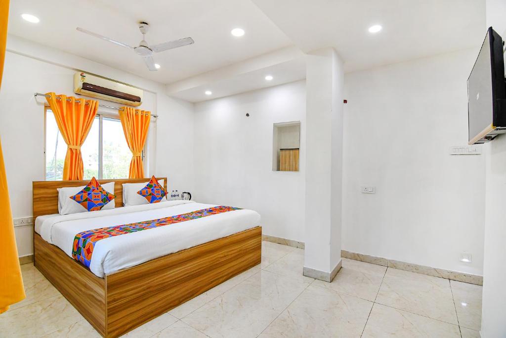 1 dormitorio con 1 cama y TV de pantalla plana en FabHotel Grand Hazra Inn en Calcuta