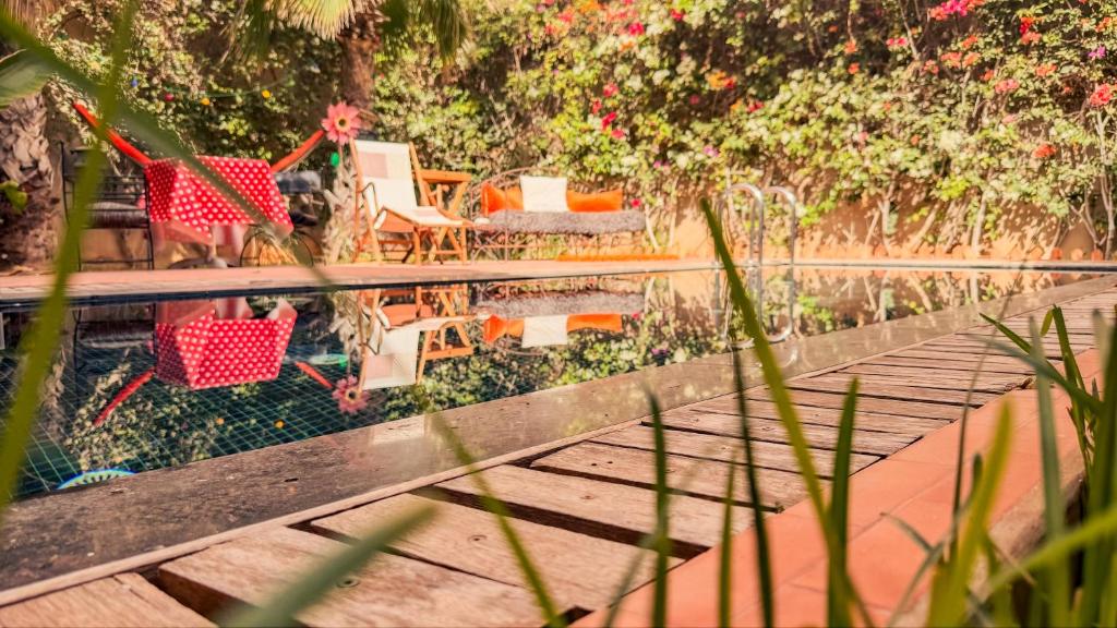 une femme en robe rouge se tient debout sur une terrasse en bois dans l'établissement Janna d'Ifni, à Sidi Ifni