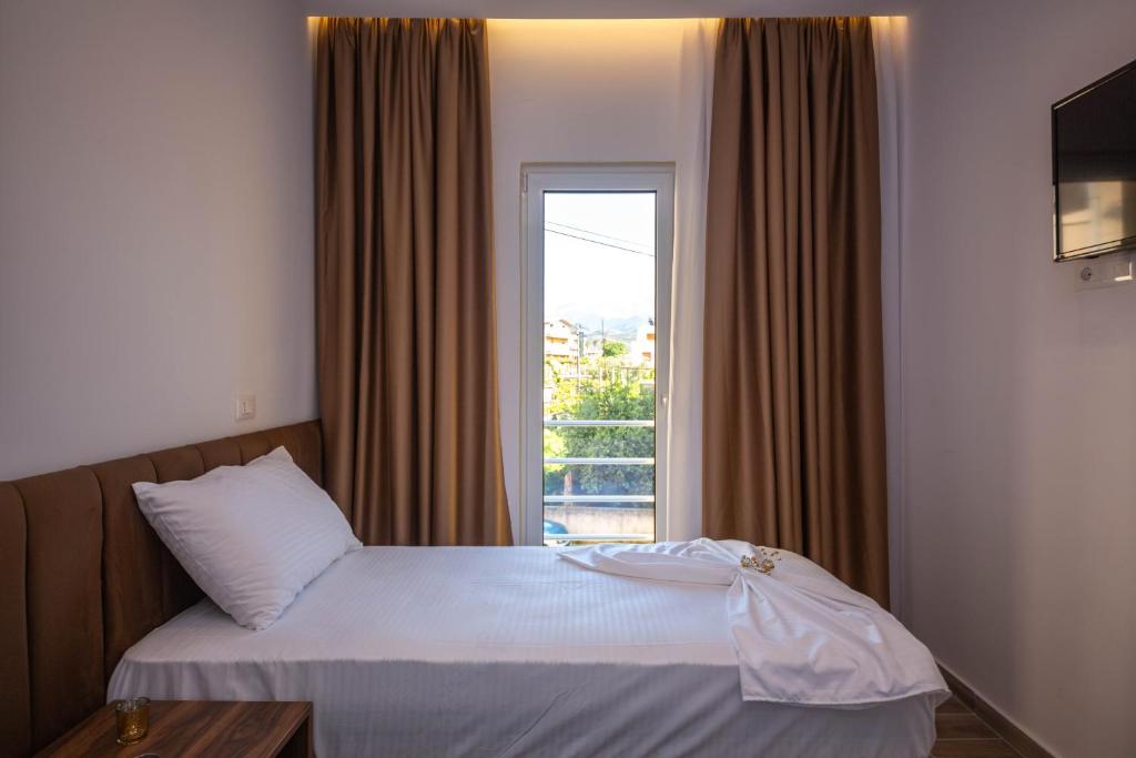 a hotel room with a bed with a window at Bebis Rooms in Orikum