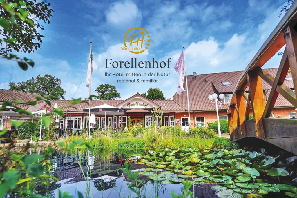 a view of the front of the hotel with a pond at Ringhotel Forellenhof in Walsrode