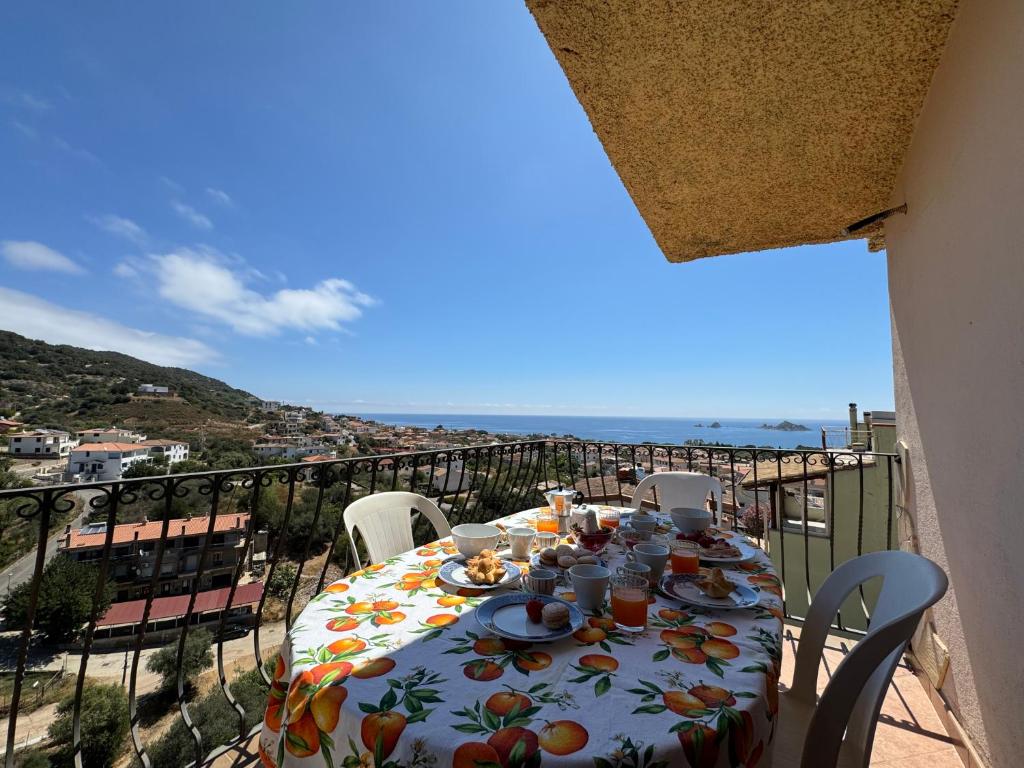 a table on a balcony with a view of the ocean at Casa Giliè A in Santa Maria Navarrese