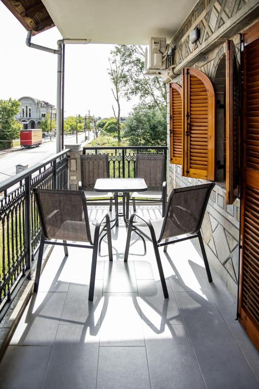 a patio with a table and two chairs on a balcony at ANGO First Floor Apartment in Stavros
