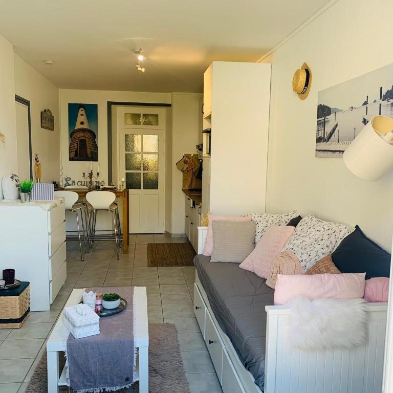 un salon avec un canapé et une table dans l'établissement Le petit nid de Katia 1, à Bernières-sur-Mer