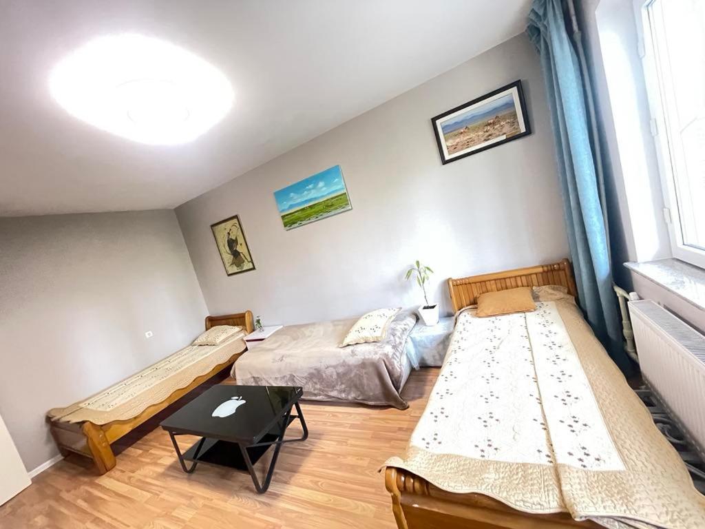 um quarto com 2 camas e uma mesa em Central Stay em Ulan Bator