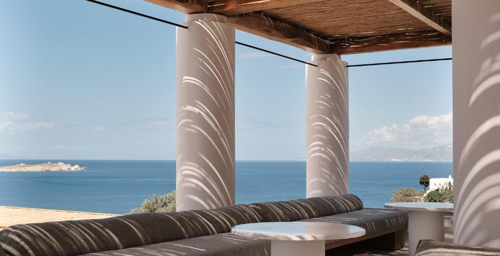 a view of the ocean from the porch of a house at Boheme Mykonos Town - Small Luxury Hotels of the World in Mikonos