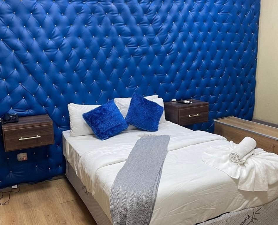 a blue padded bedroom with a bed with blue pillows at Naldorado Executive Villa in Nelspruit