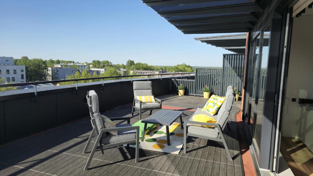 un patio con sedie e un tavolo sul balcone. di Artisa Riia Str 22 Luxury Penthouse Apartment - 8th fl a Tartu