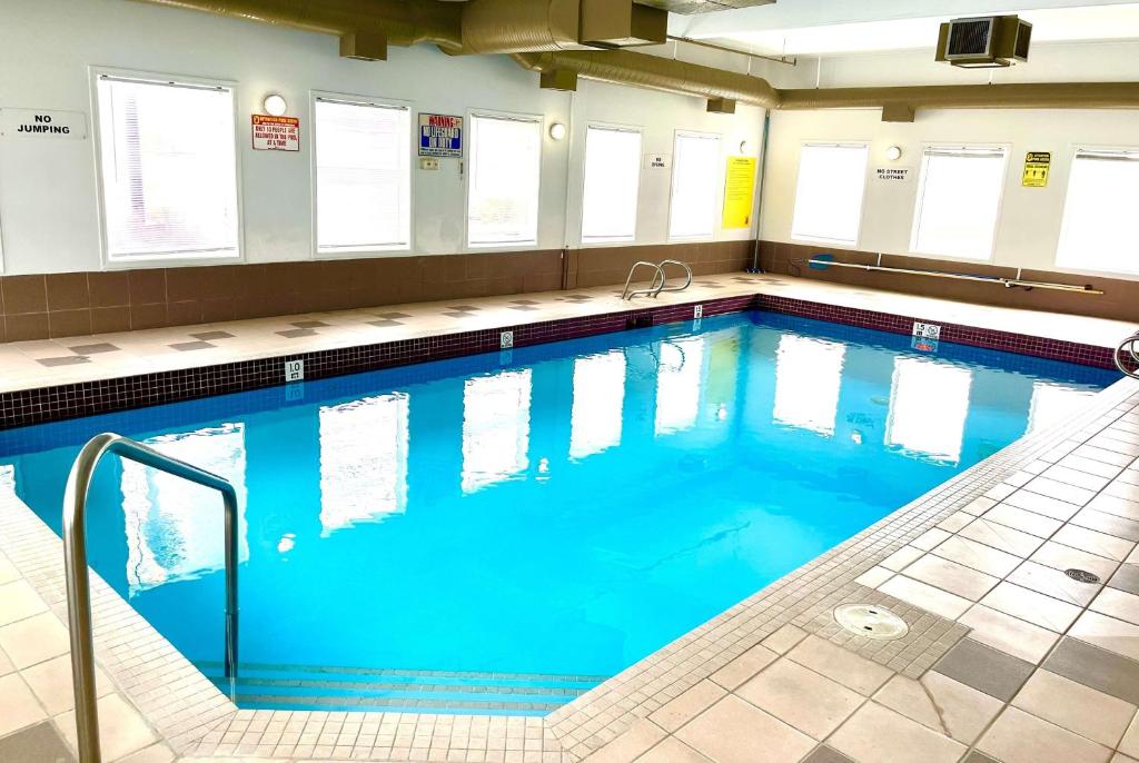 a large pool with blue water in a building at Super 8 by Wyndham Hinton in Hinton