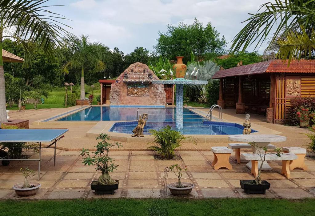 a swimming pool with a fountain in a yard at Changthai Comfort Guest House in Ban Nong Phai